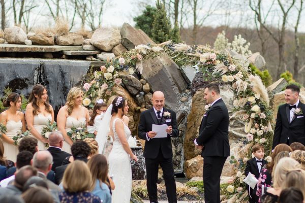 Wedding ceremony at The Barn's grotto waterfall area